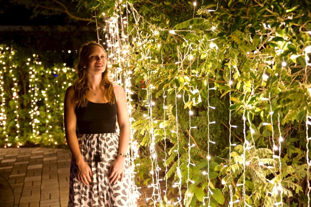 woman standing next to fairy lights