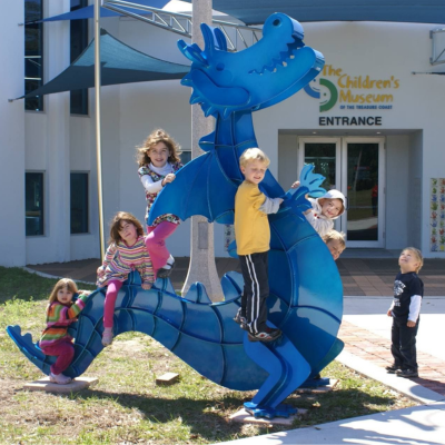 kids playing on a dragon sculpture