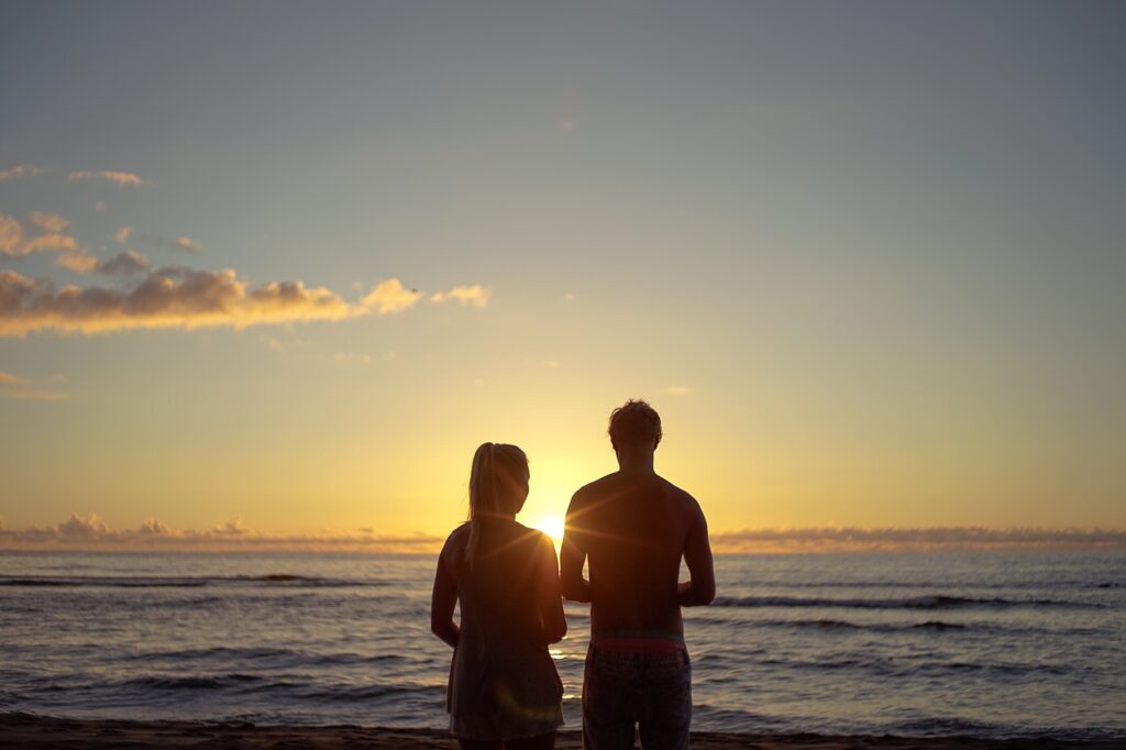 couple on beach watching the sunset